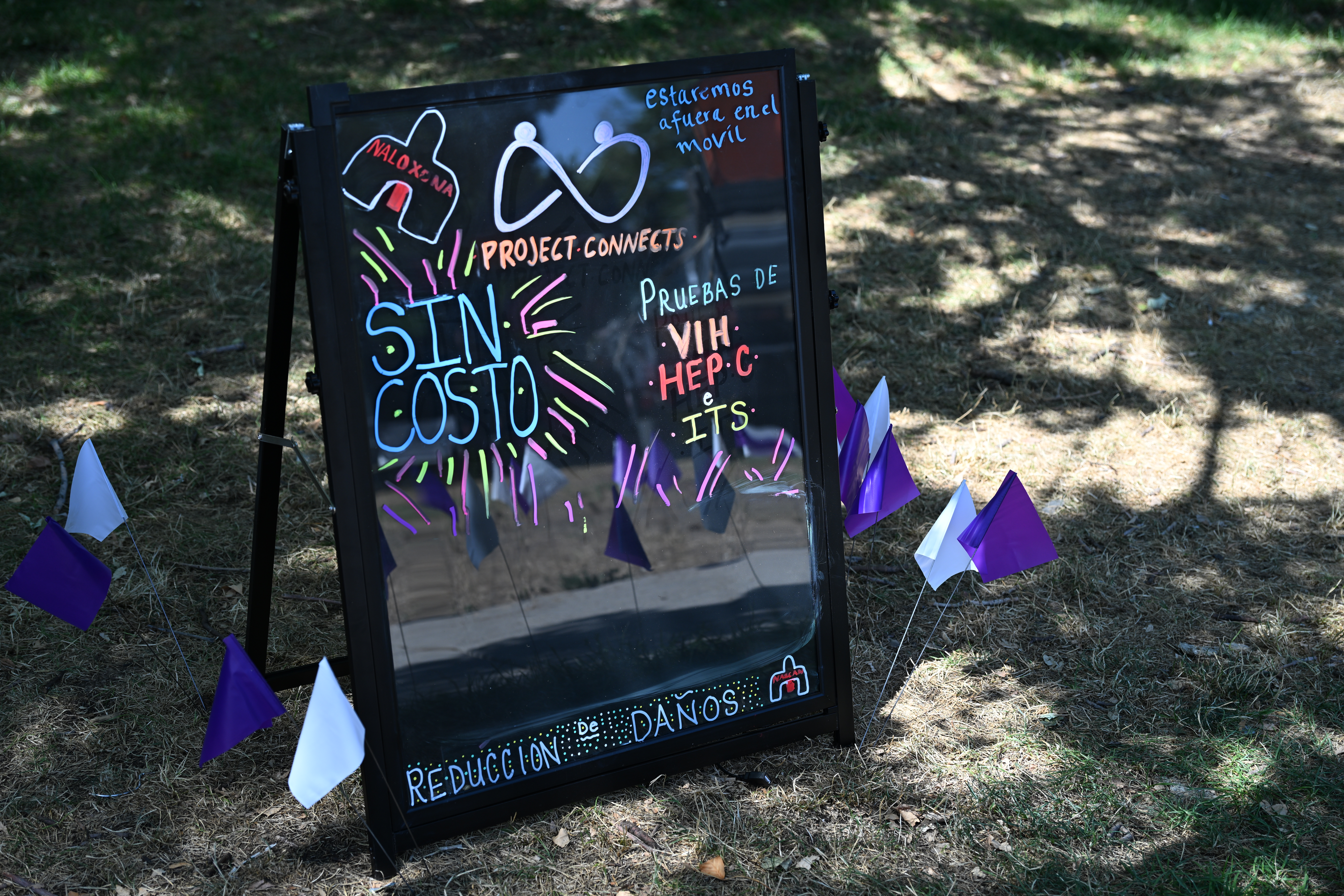 Photo of a display board showing services for Sexual Health and Harm Reduction program