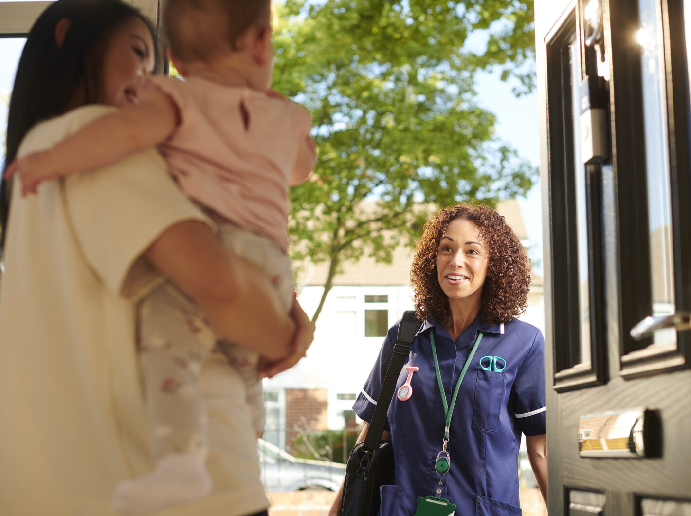 Photo of a health care nurse visiting a family at home