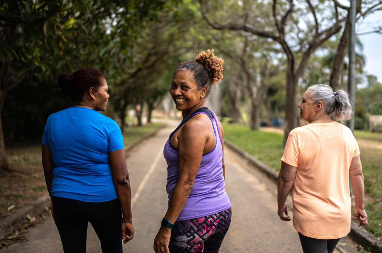 Photo of three women taking a walk, one is looking back at the camera smiling