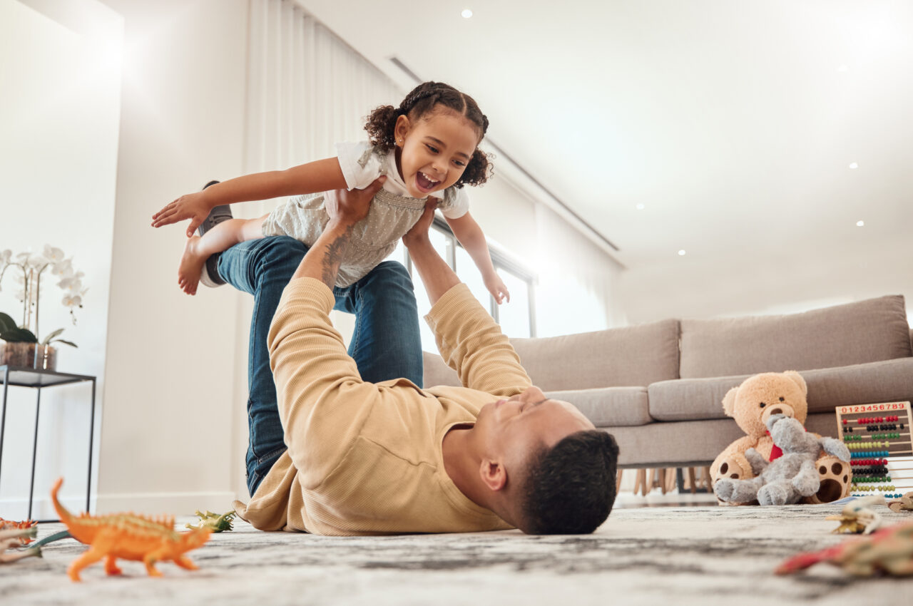Photo of a parent lifting their young child into the air