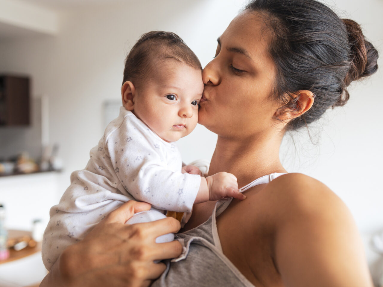 Photo of a woman kissing a baby