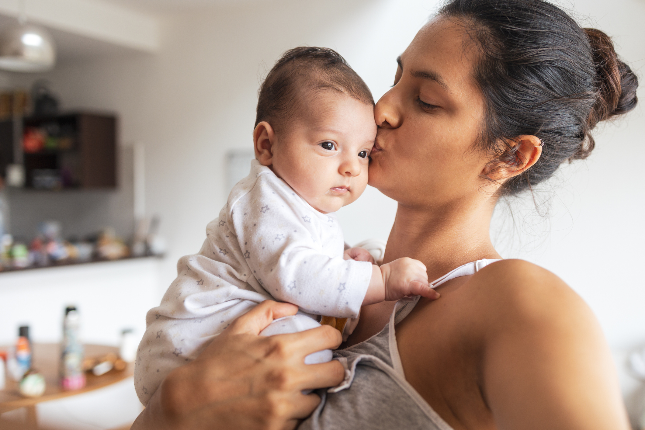 Photo of a woman kissing a baby