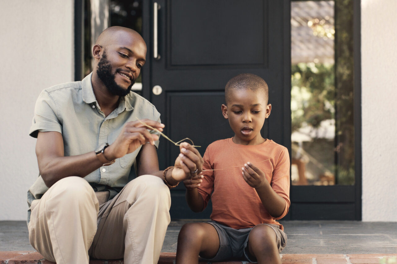 Photo of a father and child crafting together on doorstep,