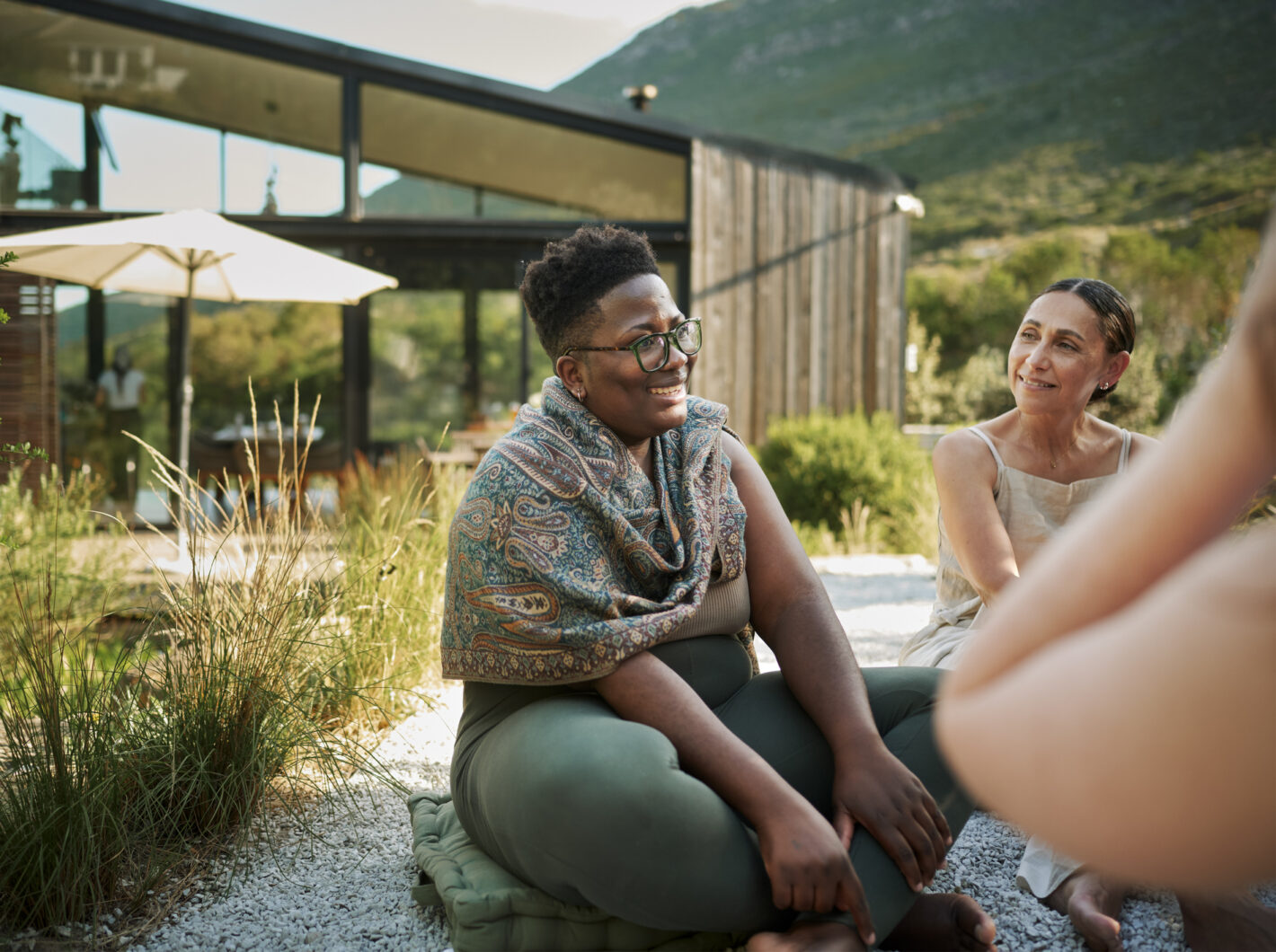 Photo of a group of people smiling while sitting outdoors